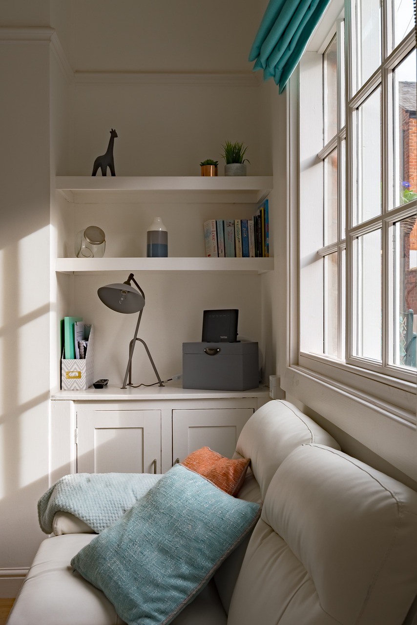 Stylish beige sofa in front of shelf in similar beige tones