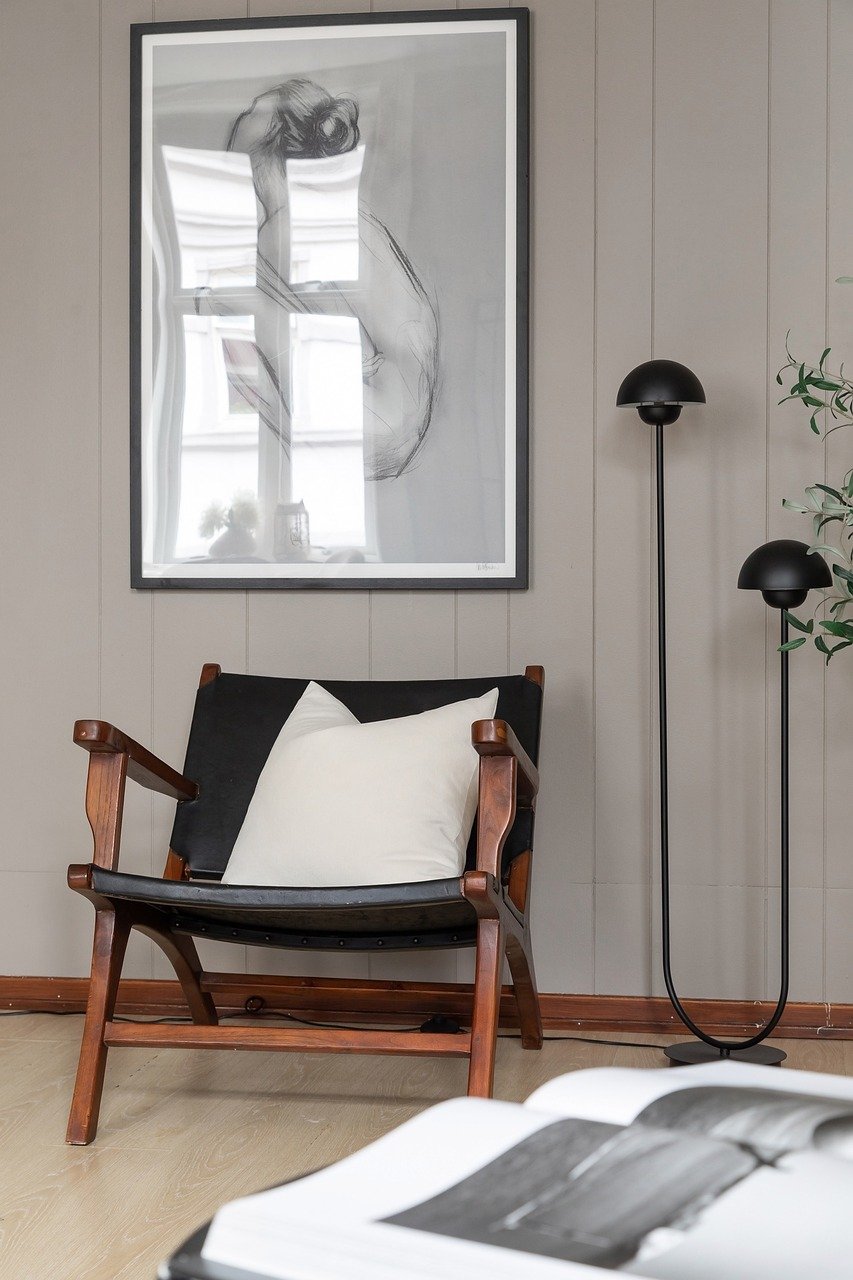 Stylish chair in brown and black colors in front of a beige wall